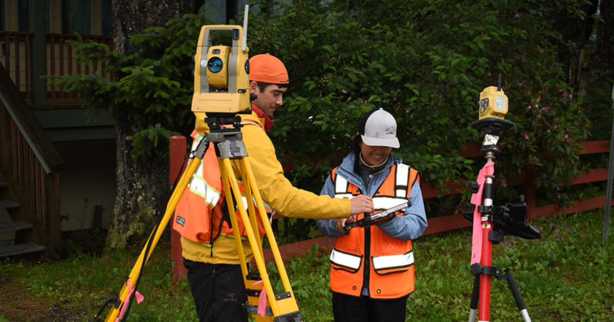 Land-Surveying_Service-Page Two people working together on a land surveying project in a residential neighborhood.