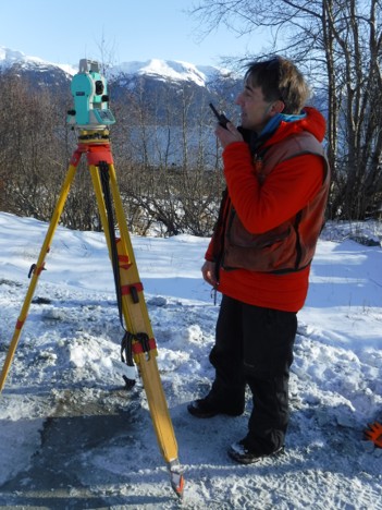 Surveying_Haines_Kelly O'Neill A professional land surveyor is working in the snow to survey property.
